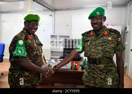 Il vice comandante uscente della forza AMISOM, responsabile delle operazioni e dei piani del generale Charles Tai Gituai (a sinistra), scuote le mani con il vice comandante della forza in arrivo, responsabile delle operazioni e dei piani del generale James Nakibus Lakara (a destra), durante una cerimonia di consegna tenutasi a Mogadiscio martedì 20 febbraio 2019. Foto Stock