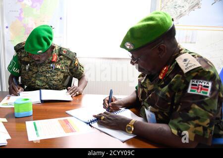 Il vice comandante della forza uscente AMISOM, responsabile delle operazioni e dei piani, Gen. Charles Tai Gituai, e il vice comandante della forza entrante, responsabile delle operazioni e dei piani, Gen. James Nakibus Lakara, firmano i documenti durante una cerimonia di consegna tenutasi a Mogadiscio martedì 20 febbraio 2019. Foto Stock