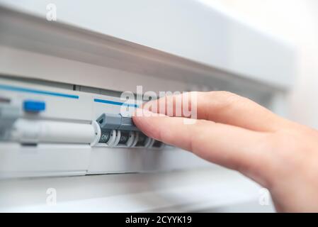 L'uomo disabilita i fusibili corrente. I dispositivi elettrici di protezione Foto Stock