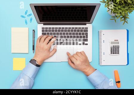 Spazio di lavoro con laptop, forniture per ufficio. Uomo che lavora su un elegante tavolo da lavoro Foto Stock