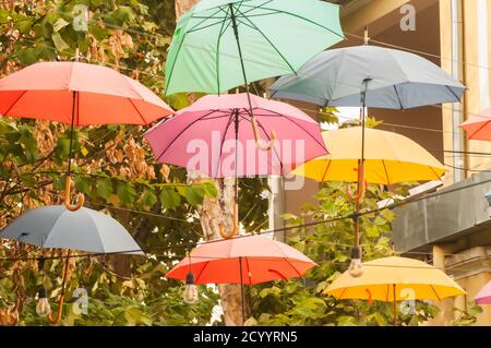 Ombrelloni in diversi colori appesi sulla strada della città Foto Stock