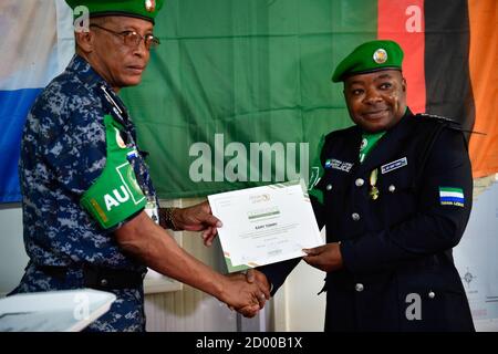 Il commissario della polizia AMISOM, ispettore generale della polizia (AIGP), Augustine Magnus Kailie consegna un certificato ad un singolo ufficiale di polizia (IPO), che opera sotto la missione dell'Unione Africana in Somalia (AMISOM) che ha completato il suo viaggio di un anno in Somalia il 15 gennaio 2020. Foto Stock