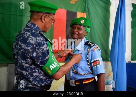 Il commissario di polizia AMISOM, ispettore generale aggiunto della polizia (AIGP), Augustine Magnus Kailie, insegna una medaglia su un agente di polizia che opera sotto la missione dell'Unione Africana in Somalia (AMISOM), durante una cerimonia di premiazione a Mogadiscio per celebrare il completamento di un anno di viaggio di servizio in Somalia, il 15 gennaio 2020. Foto Stock