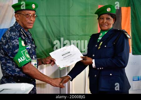 Il commissario della polizia AMISOM, ispettore generale della polizia (AIGP), Augustine Magnus Kailie consegna un certificato ad un singolo ufficiale di polizia (IPO), che opera sotto la missione dell'Unione Africana in Somalia (AMISOM) che ha completato il suo viaggio di un anno in Somalia il 15 gennaio 2020. Foto Stock