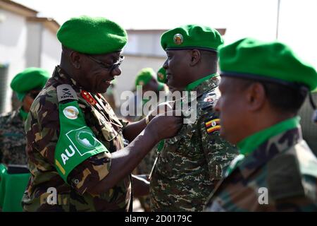 Charles Tai Gituai, la Missione dell'Unione Africana in Somalia (AMISOM), Vice comandante della forza, infigura una medaglia di servizio ad un ufficiale militare ugandese durante una cerimonia di premiazione delle medaglie per i funzionari del personale AMISOM a Mogadiscio il 13 giugno 2018. Foto Stock