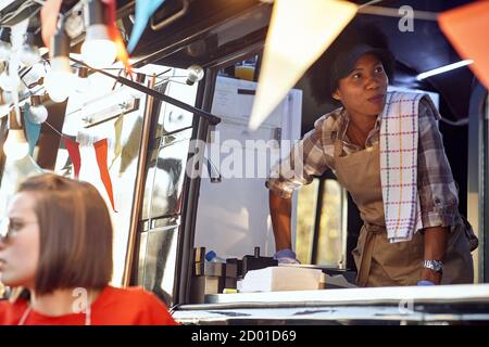 afroamericano alimentare camion dipendente che prende ordini dai clienti Foto Stock