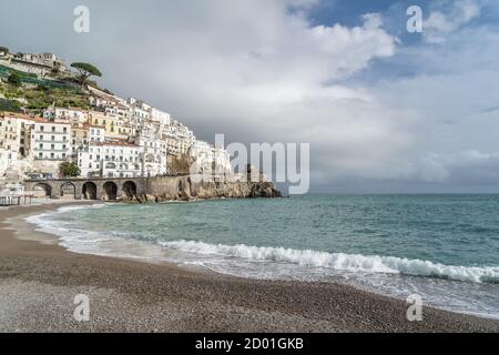 Vista sulla bellissima Amalfi con la sua spiaggia. Cielo scuro con temporale in arrivo. Costiera Amalfitana, Campania, Italia. Foto Stock