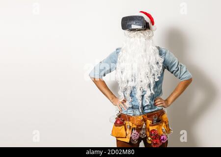 Babbo Natale indossa occhiali per realtà virtuale su sfondo bianco. Natale Foto Stock