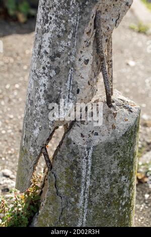 Un bullard in cemento fratturato da vicino in formato ritratto Foto Stock