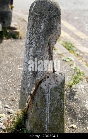 Un bullard in cemento fratturato da vicino in formato ritratto Foto Stock