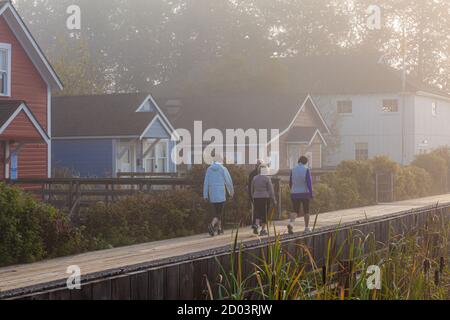 Quattro donne che camminano lungo la passerella Britannia Ship Yard Una mattina foggy in Steveston British Columbia Canada Foto Stock