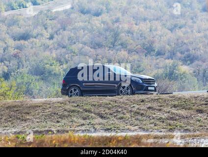 Il moderno SUV si trova su un'autostrada suburbana Foto Stock