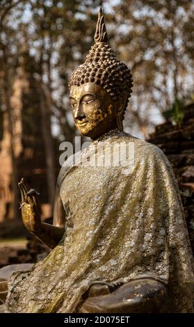 Antico in pietra Budda seduto con un palmo sollevato. Foto Stock