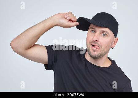 Uomo cresciuto in un cappellino nero e una t-shirt. Sessione fotografica nello Studio su sfondo bianco Foto Stock