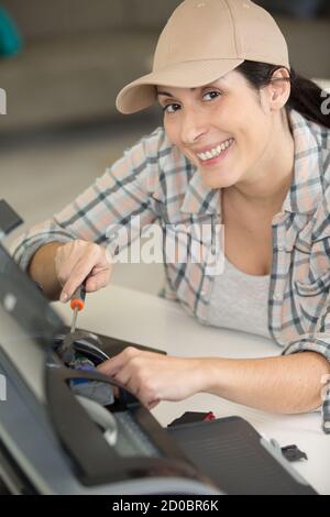 felice donna che ripara una stampante Foto Stock