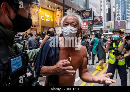 Un uomo si oppone a un poliziotto in rivolta durante una protesta vietata a Hong Kong, in Cina, il 1° ottobre 2020. La polizia ha dispiegato 6,000 ufficiali durante il 71° anniversario della Giornata Nazionale della Cina per contrastare qualsiasi protesta e assemblea illegale a Hong Kong. Foto Stock