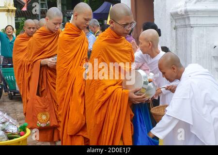 In occasione della vacanza buddista OK Phansa, laici e monache buddiste bianche danno elemosina ai monaci buddisti; Wat Sam Phraya, Bangkok, Thailandia Foto Stock