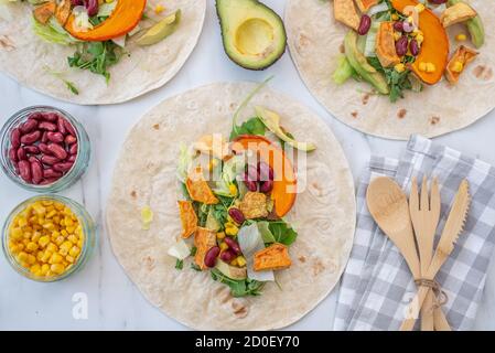 Tortilla vegane aperte con patate dolci, fagioli, avocado e zucca Foto Stock