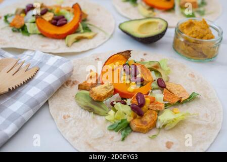 Tortilla vegane aperte con patate dolci, fagioli, avocado e zucca Foto Stock