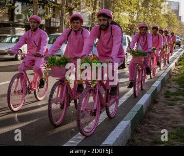 Tehran, Iran - 2019-04-03 - Uomini in bici in rosa per promuovere la nuova moto la società di noleggio. Foto Stock