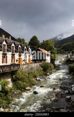 Case sulle rive di un fiume di montagna. Foto Stock