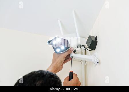 I tecnici stanno installando telecamere TVCC wireless sulle pareti della casa per motivi di sicurezza. Foto Stock