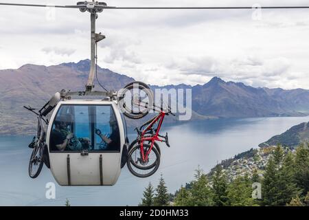 Queenstown, Nuova Zelanda: Trasporto in bicicletta con la Skyline Gondola. Sullo sfondo la vista panoramica del lago Wakatipu. Foto Stock