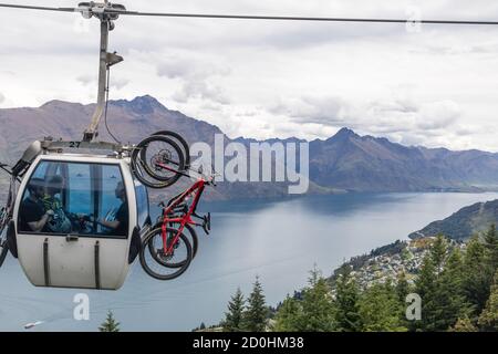 Queenstown, Nuova Zelanda: Trasporto in bicicletta con la Skyline Gondola. Sullo sfondo la vista panoramica del lago Wakatipu. Foto Stock
