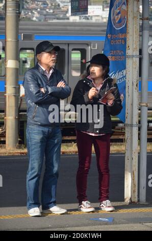 Pendolari in attesa sul binario alla stazione JR di Nagasaki Foto Stock