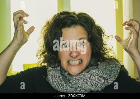 Una giovane donna fissa la macchina fotografica, i suoi occhi spalancati e la bocca larga. Foto Stock