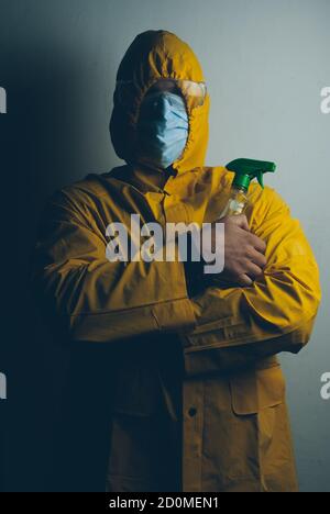 ritratto di un uomo in tuta protettiva con disinfettante, Foto Stock