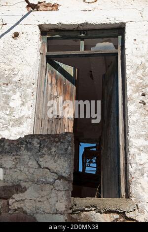 Sedia dilapidata lasciata su un tavolo in una casa abbandonata situata in un villaggio nella zona montagnosa di Psiloritis, Creta, Grecia. Foto Stock