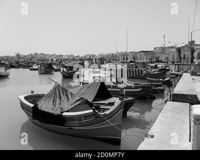 Piccolo porto di Valletta capitale dell'isola di Malta con le tipiche barche da pesca in legno. Foto Stock