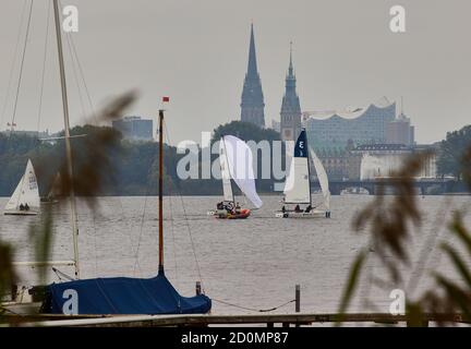 Amburgo, Germania. 03 ottobre 2020. Le barche a vela navigano sull'Alster. Sullo sfondo si può vedere la sala concerti Elbphilharmonie, il municipio e il ponte Lombardsbrücke. Credit: Georg Wendt/dpa/Alamy Live News Foto Stock