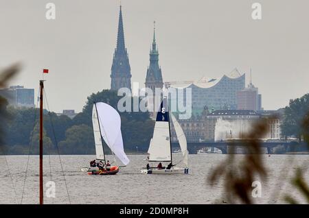 Amburgo, Germania. 03 ottobre 2020. Le barche a vela navigano sull'Alster. Sullo sfondo si può vedere la sala concerti Elbphilharmonie, il municipio e il ponte Lombardsbrücke. Credit: Georg Wendt/dpa/Alamy Live News Foto Stock