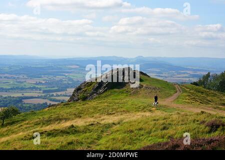 Lady camminando il suo cane sulla cima del Wrekin, vicino a Telford, Shropshire, Regno Unito Foto Stock