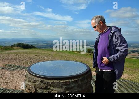 Uomo che guarda il toposcopio sulla cima del Wrekin, vicino a Telford, Shropshire, Regno Unito Foto Stock