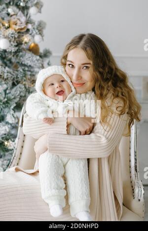 Ritratto di una madre felice e di un bambino di charme che celebra il Natale. Vacanza di nuovo anno. Bambino con mamma in una stanza festively decorata con un Natale Foto Stock