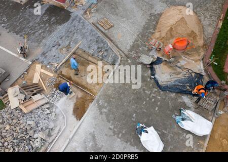 i lavoratori posano le lastre di pavimentazione vista dall'alto. Foto Stock