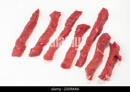 Bistecca di manzo tagliata a strisce su sfondo bianco Foto Stock
