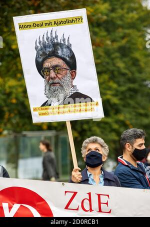 Amburgo, Germania. 03 ottobre 2020. Un partecipante di una manifestazione di fronte alla Moschea Blu ha una bandiera con l'iscrizione: 'Atomic accordo con Ayatollah? Ali Khamenei esporta il terrore, vuole distruggere Israele, nega l'olocausto!!". Iraniani e altri partecipanti hanno manifestato, tra l'altro, durante la Giornata della Moschea aperta per la chiusura della Moschea Blu e per l'immediata cessazione del trattato di Stato con le associazioni islamiche ortodosse. Credit: Georg Wendt/dpa/Alamy Live News Foto Stock