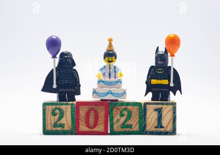 il batman lego e il vader darth tengono una mongolfiera che celebra il nuovo anno 2021, utilizzando un blocco di legno. Foto Stock