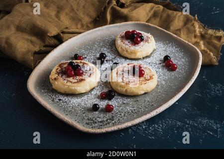 frittelle al formaggio con frutti di bosco e zucchero in polvere Foto Stock