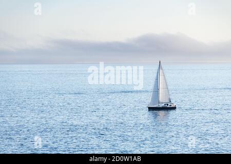 Una barca solitaria parte dall'isola di Ons nella Ria de Pontevedra in Galizia al tramonto. Foto Stock