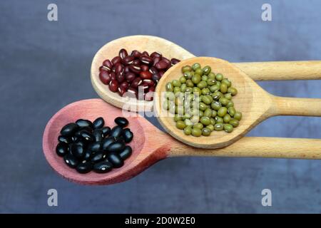 Fagioli neri e rossi e fagioli verdi su cucchiaio di legno, Germania, Europa Foto Stock