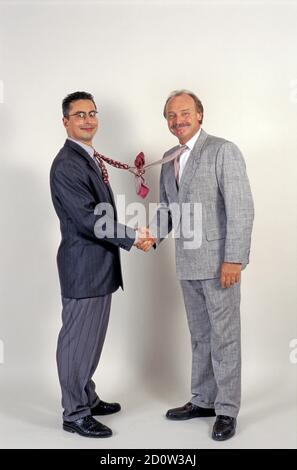 Uomini d'affari scuotono le mani, divertente, legano annodato, Berlino, Germania, Europa Foto Stock