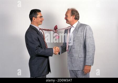 Uomini d'affari scuotono le mani, divertente, legano annodato, Berlino, Germania, Europa Foto Stock