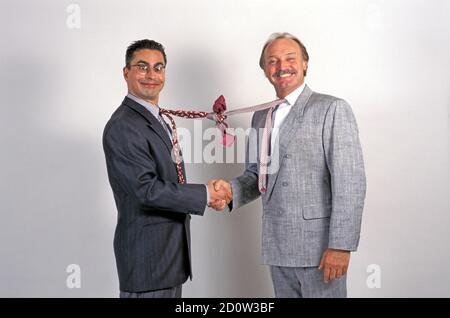 Uomini d'affari scuotono le mani, divertente, legano annodato, Berlino, Germania, Europa Foto Stock