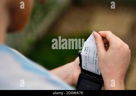 Un giovane carica un film fotografico in una telecamera analogica, un mezzo che vede una rinascita negli ultimi anni (MR) Foto Stock