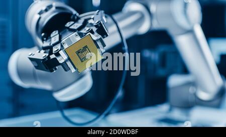 Moderno High Tech autentico braccio robot che tiene contemporaneo Super computer processore. Chip della CPU di supporto dell'effettore terminale del manipolatore robotico industriale Foto Stock